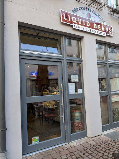 Eingang des Liquid Beans Cafés mit gemütlicher Innenansicht